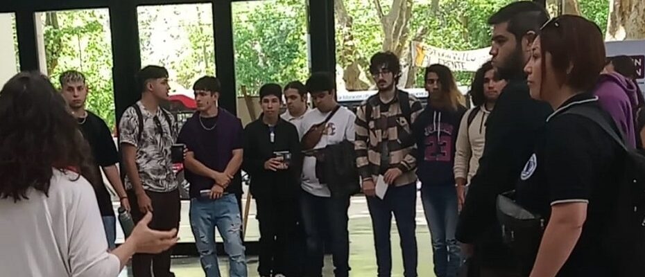 Estudiantes de escuelas secundarias reciben la bienvenida en el hall de la Facultad de Informática.