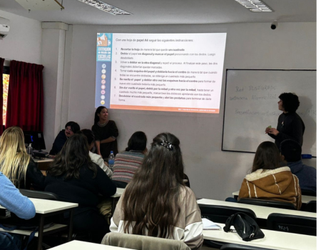 Banner colorido con ilustraciones de jóvenes moviéndose; título en blanco sobre una forma geométrica: El barrio va a la Universidad: Alfabetización Digital y Lectoescritura.